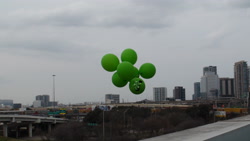 Size: 3840x2160 | Tagged: safe, oc, oc:filly anon, balloon, city, female, filly, floating, foal, harmonycon, harmonycon 2026, imported from derpibooru, irl, oc only, outdoors, overcast, photo, plushie, solo